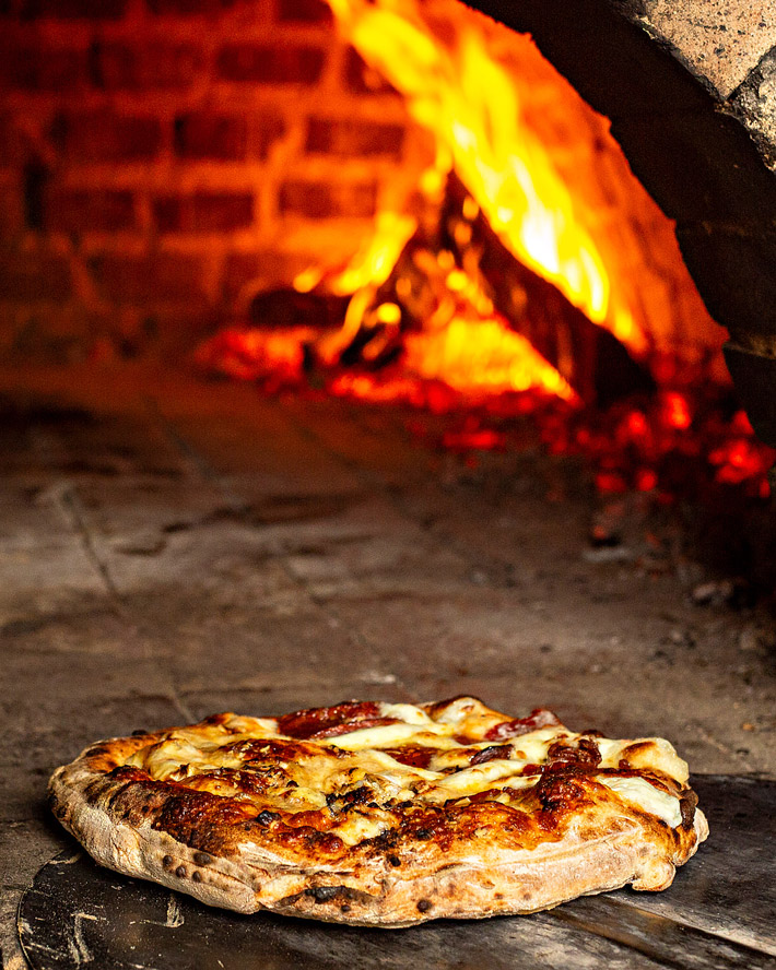 Fotografia gastronômica de pizza em forno a lenha